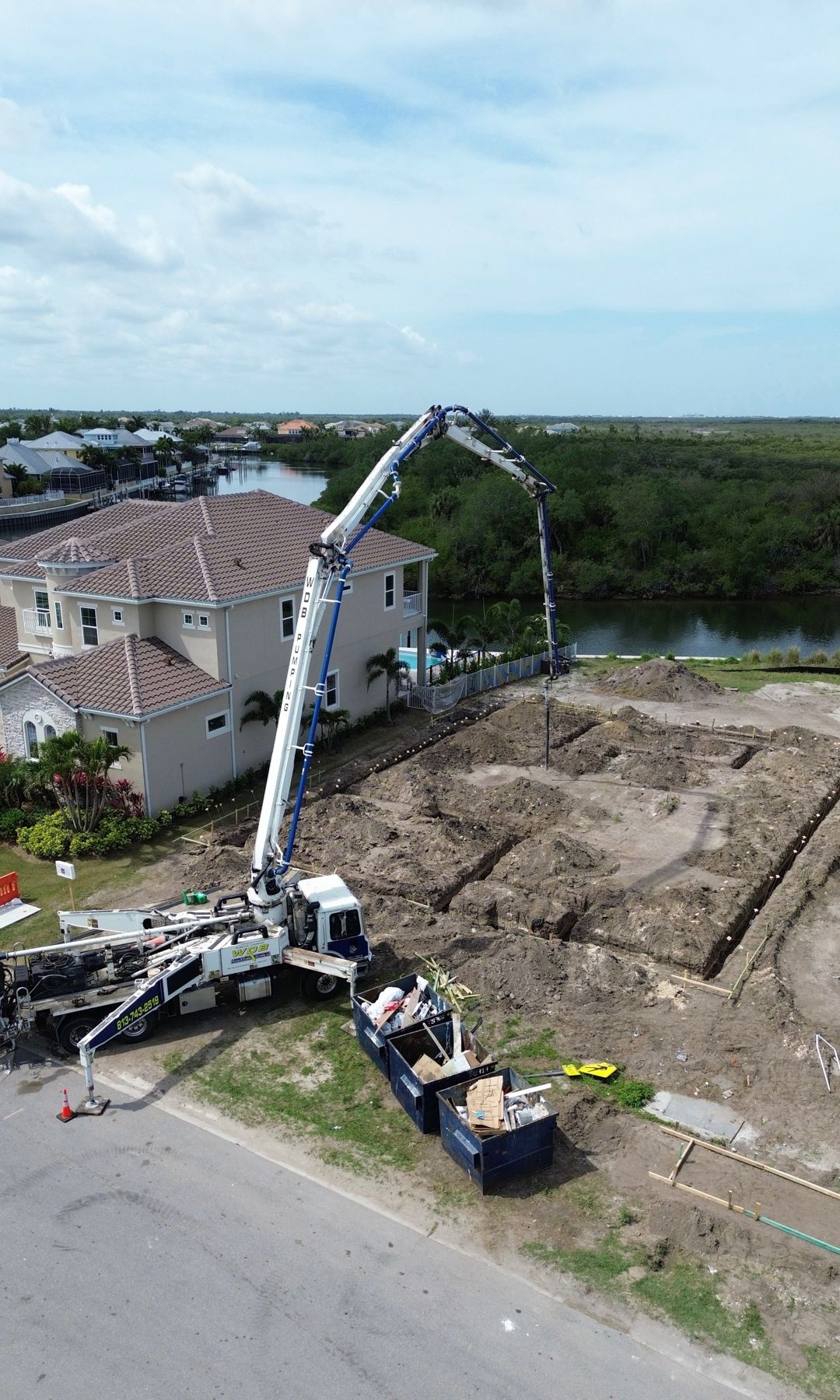 WDB boom reaching over a lot to pour footings beside a canal