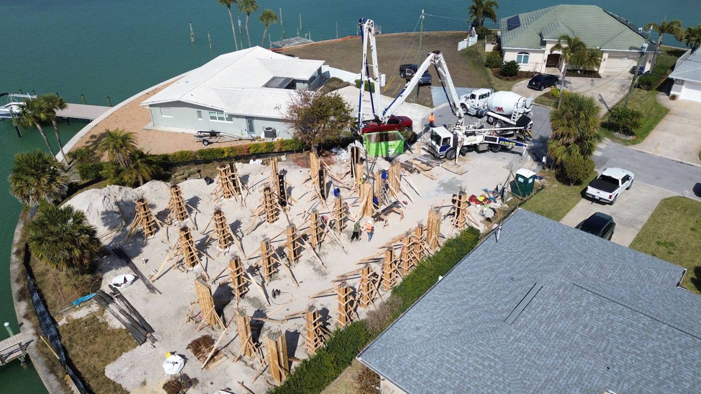 Two boom pumps filling column forms on a waterfront lot
